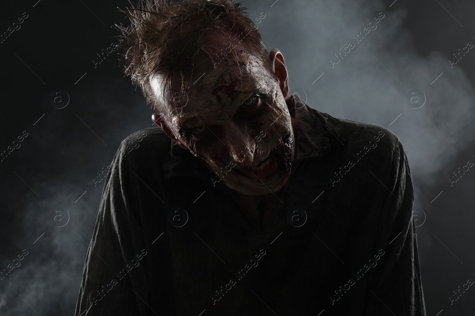 Photo of Scary zombie on dark background. Halloween monster