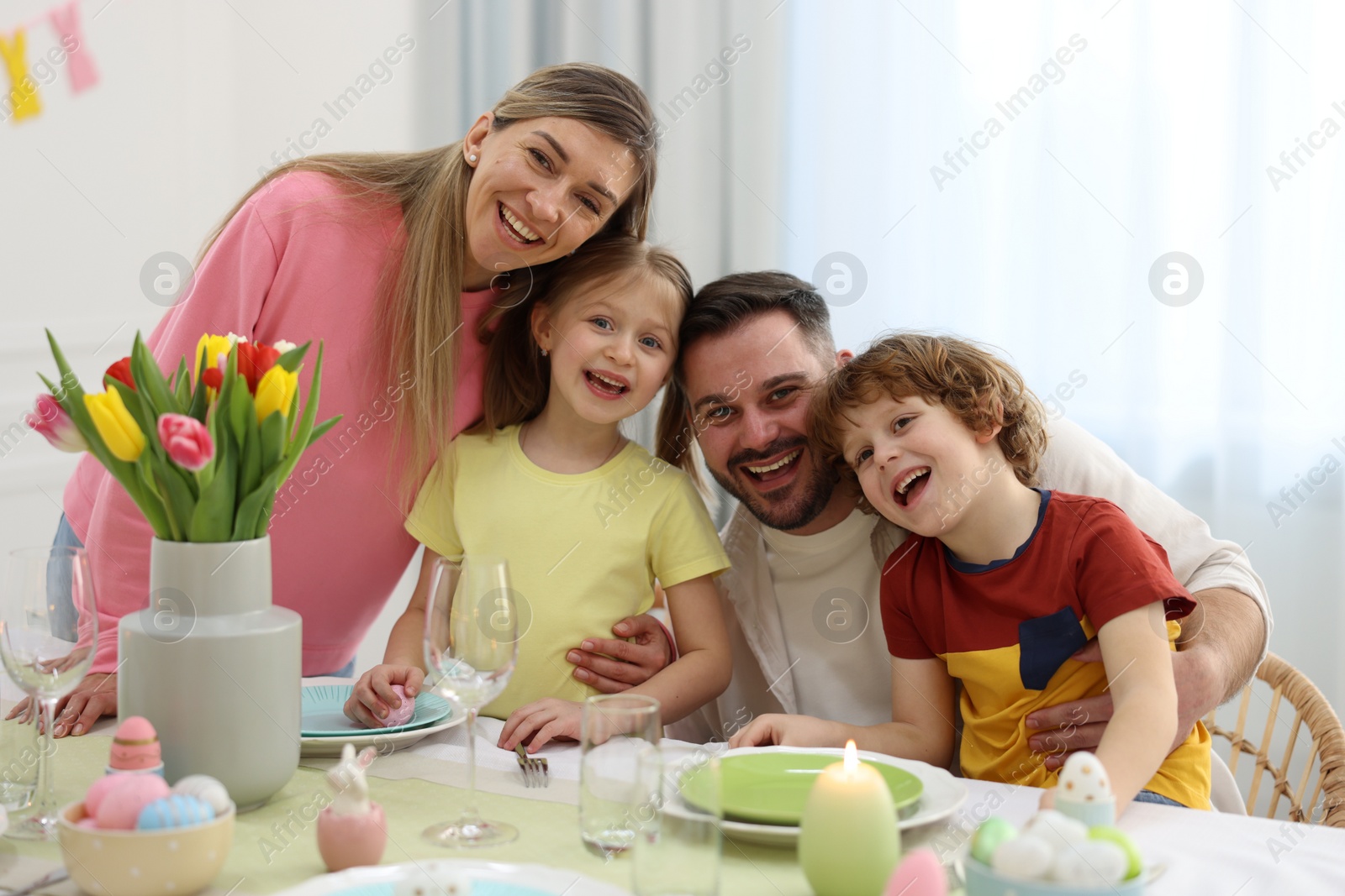 Photo of Easter celebration. Portrait of happy family at served table in room