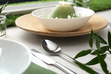 Photo of Elegant cutlery with green plant on table, closeup. Festive setting