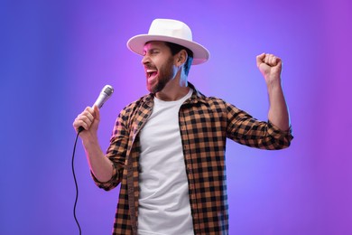 Emotional man with microphone singing in neon lights