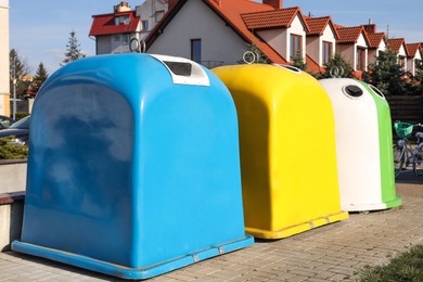 Bright colorful recycling bins outdoors on sunny day