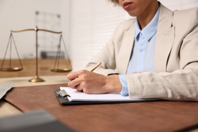 Photo of Notary with clipboard writing notes at workplace in office, closeup