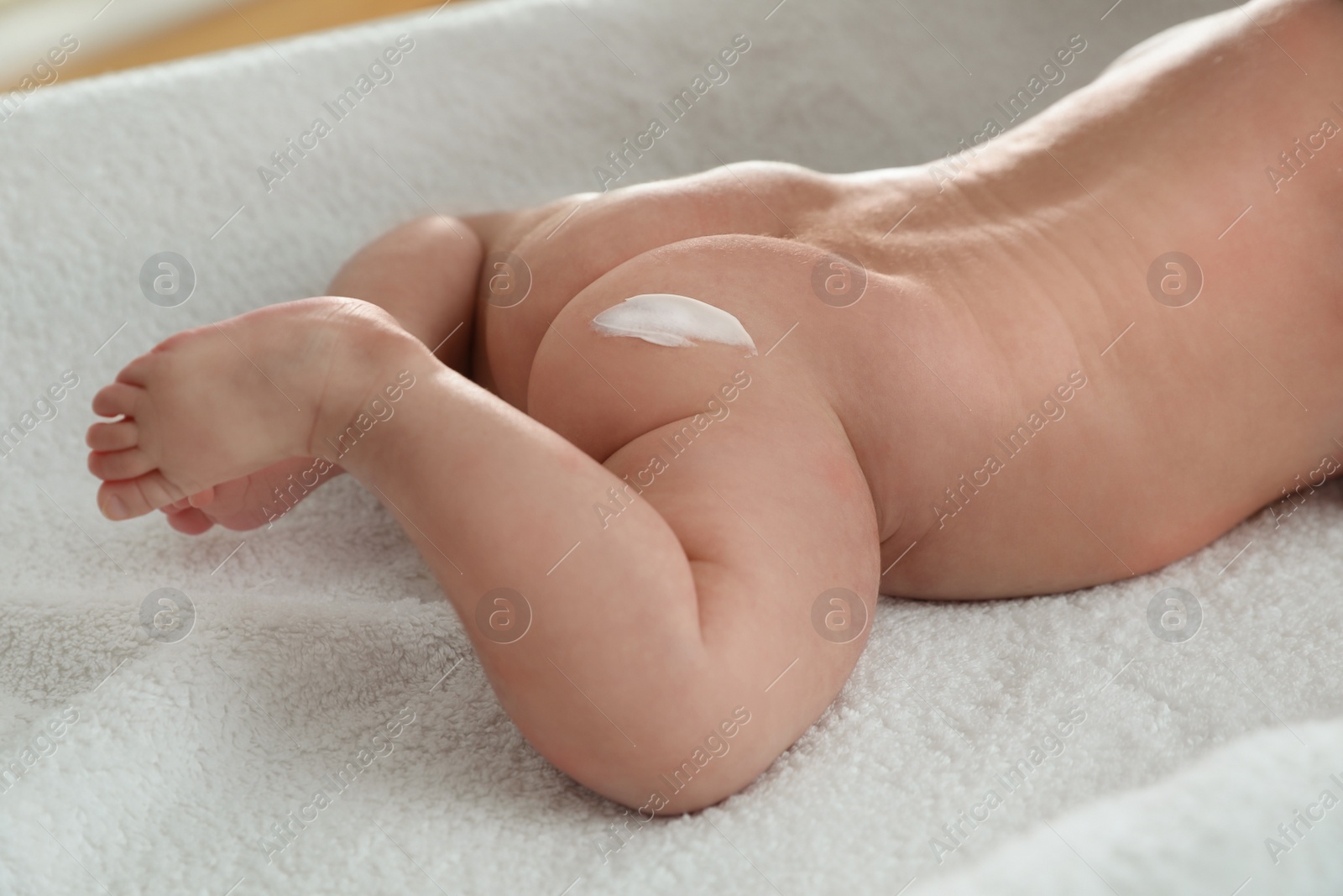 Photo of Cute little baby with cream on body, closeup
