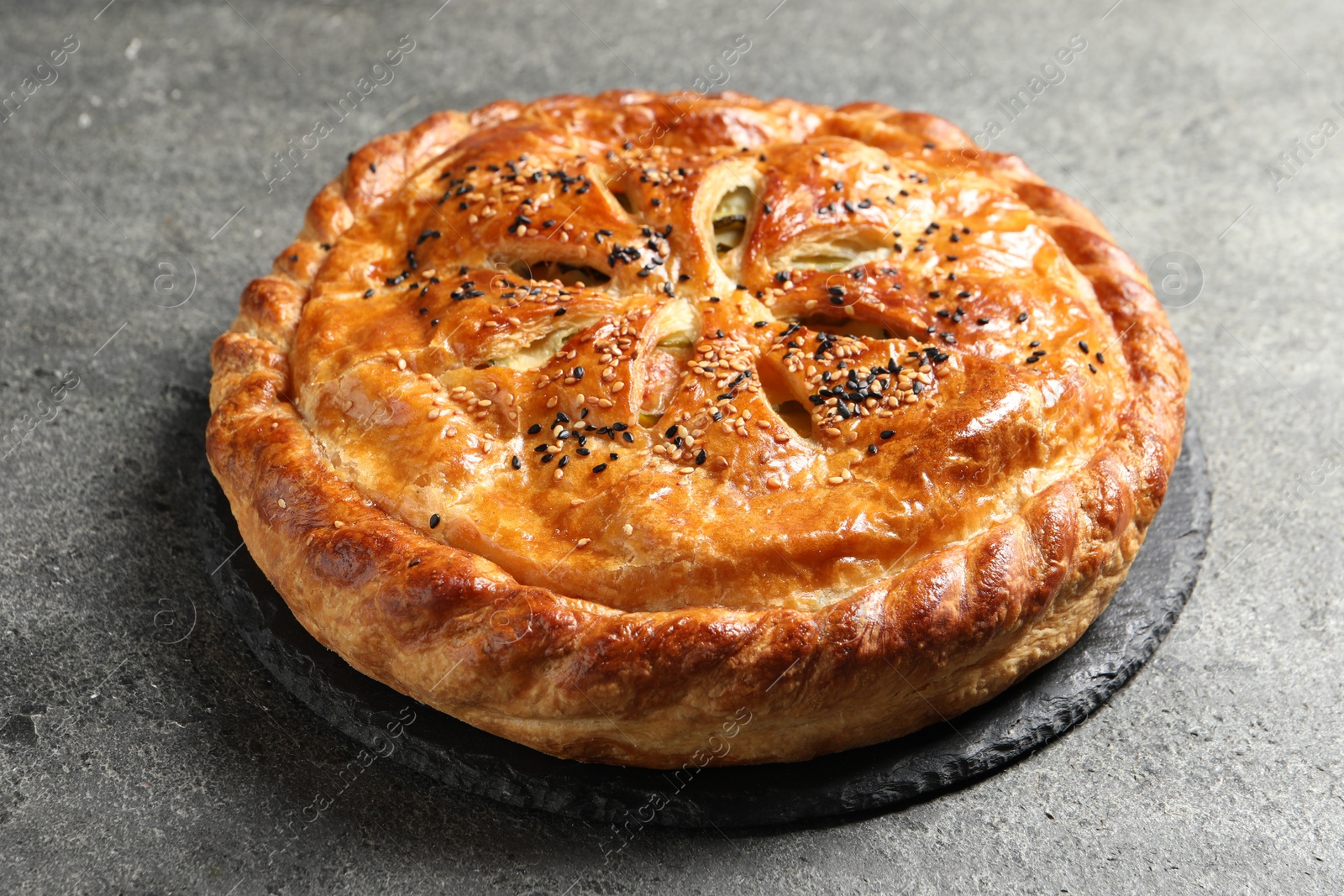 Photo of Tasty homemade pie with filling on grey table