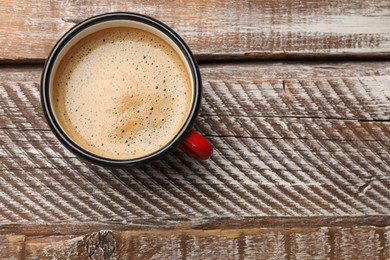 Photo of Cup of aromatic coffee on wooden table, top view. Space for text