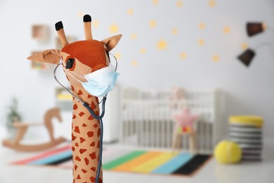 Image of Toy giraffe with face mask and stethoscope indoors, space for text. Pediatrician practice