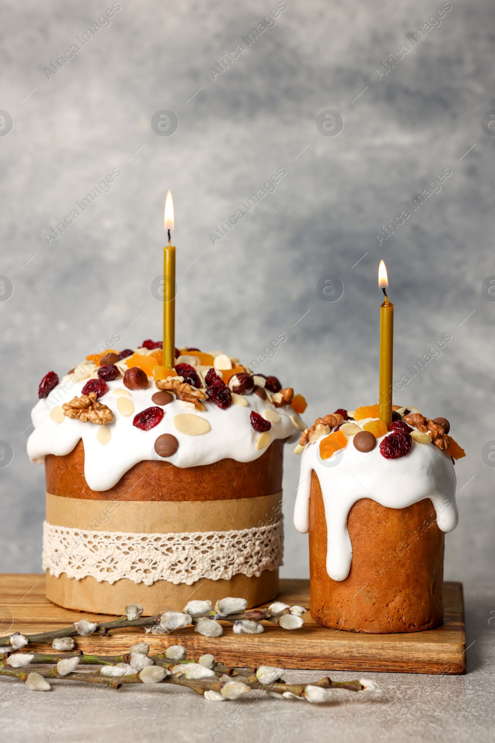 Photo of Tasty Easter cakes and willow branches on grey table