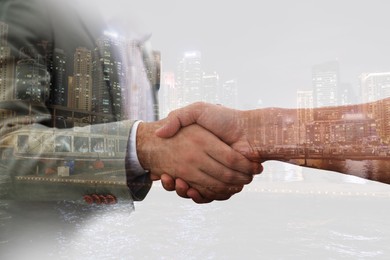 Image of Double exposure of partners shaking hands and cityscape