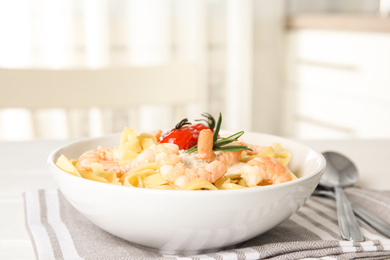 Delicious pasta with shrimps on table indoors