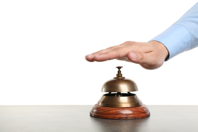 Photo of Man ringing hotel service bell at grey stone table