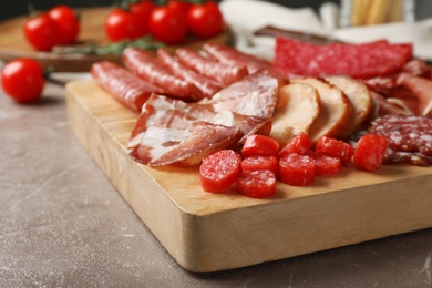 Photo of Cutting board with different sliced meat products served on table