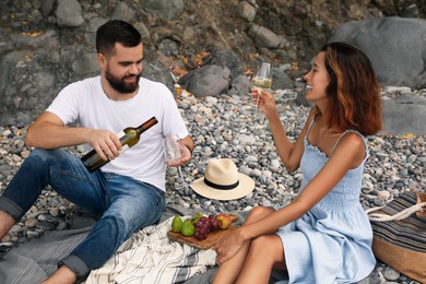 Photo of Happy young couple having picnic on beach