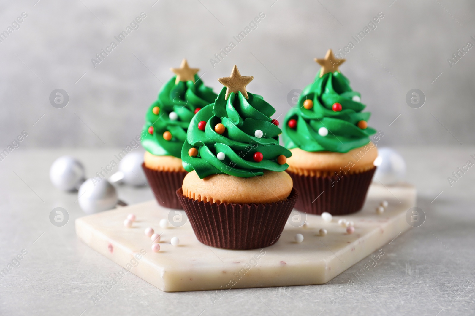 Photo of Christmas tree shaped cupcakes on light grey table