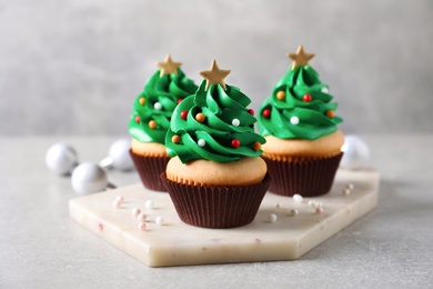 Christmas tree shaped cupcakes on light grey table