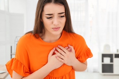 Photo of Young woman suffering from heart attack at home