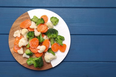 Photo of Mix of different frozen vegetables on blue wooden table, top view. Space for text