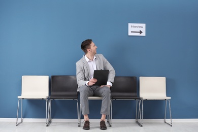 Young man waiting for job interview, indoors