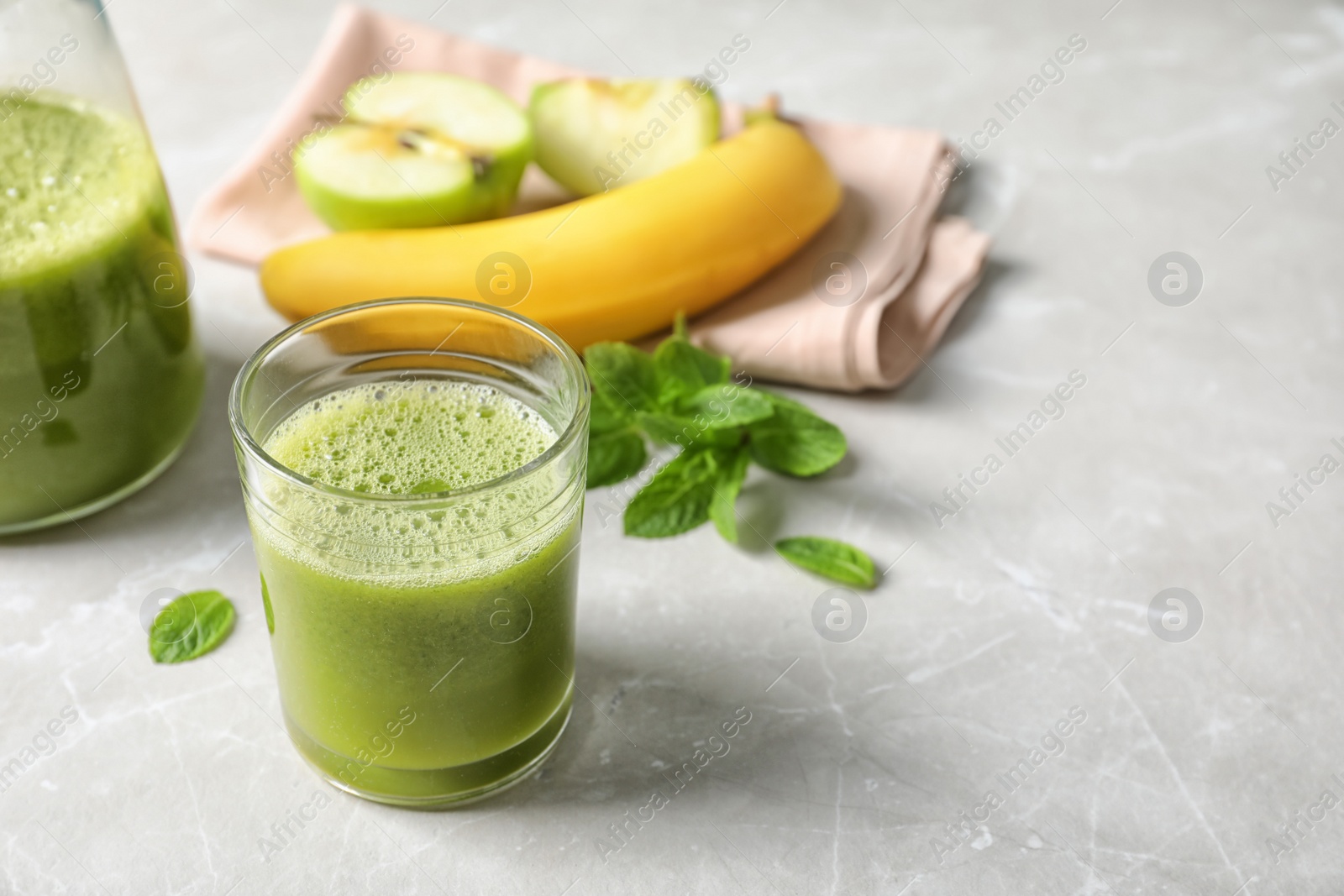 Photo of Glass with delicious detox juice and ingredients on table