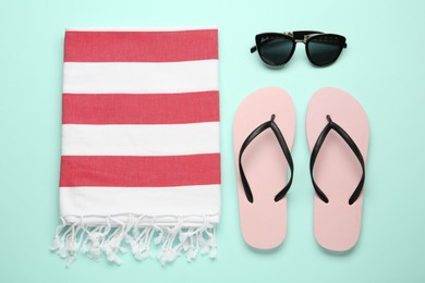 Flat lay composition with different beach objects on light blue background