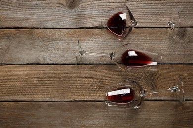 Winemaking. Glasses with wine on wooden table, flat lay. Space for text