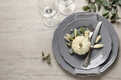 Photo of Festive table setting with autumn decor on wooden background, flat lay. Space for text