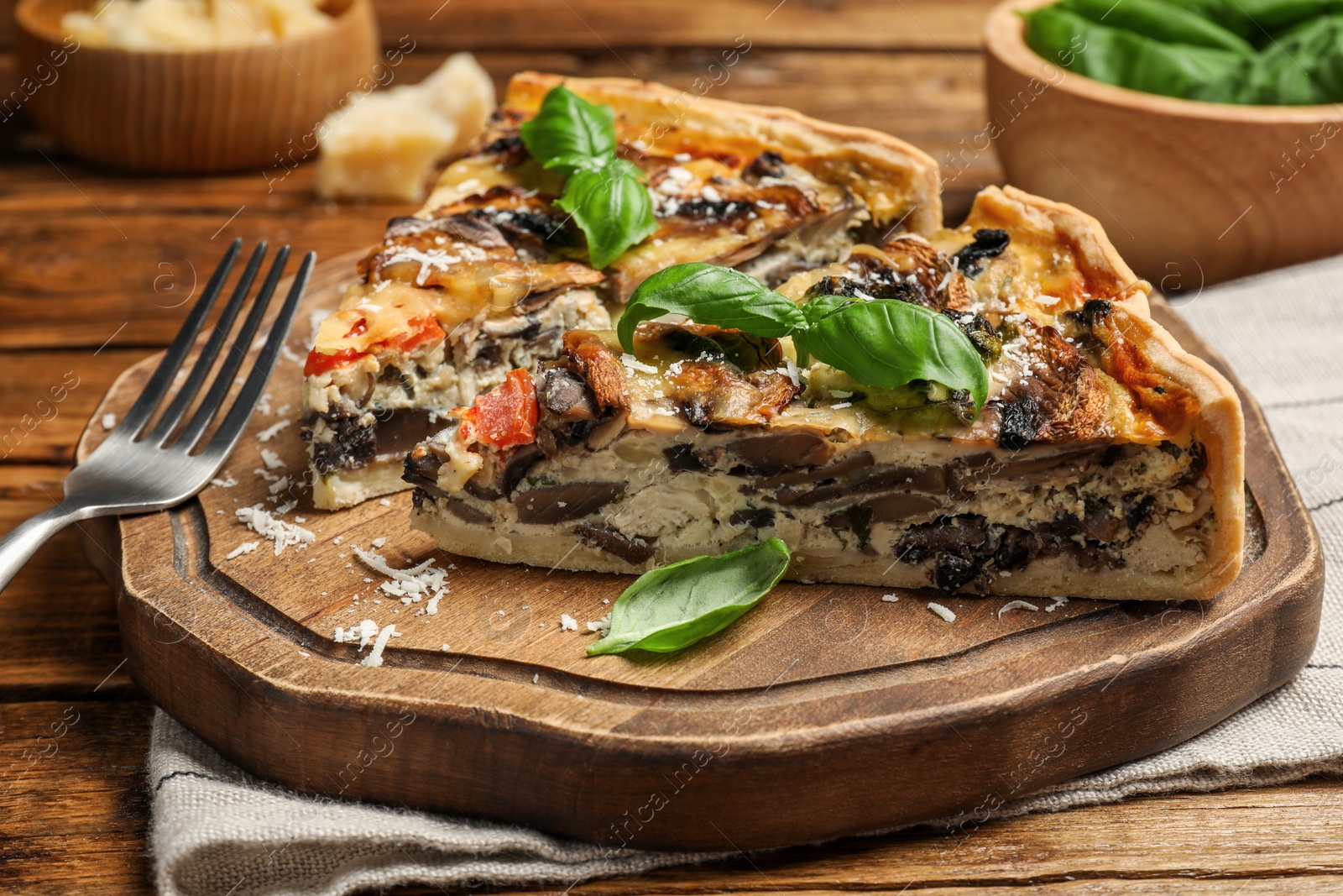 Photo of Pieces of delicious quiche with mushrooms served on wooden table, closeup