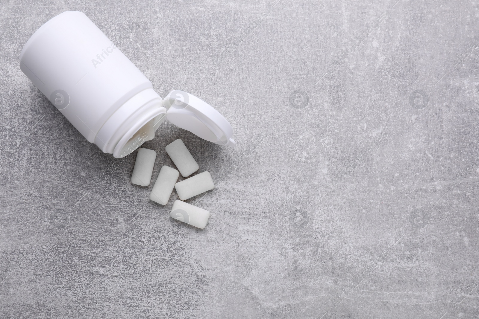 Photo of Jar with chewing gums on light grey table, flat lay. Space for text