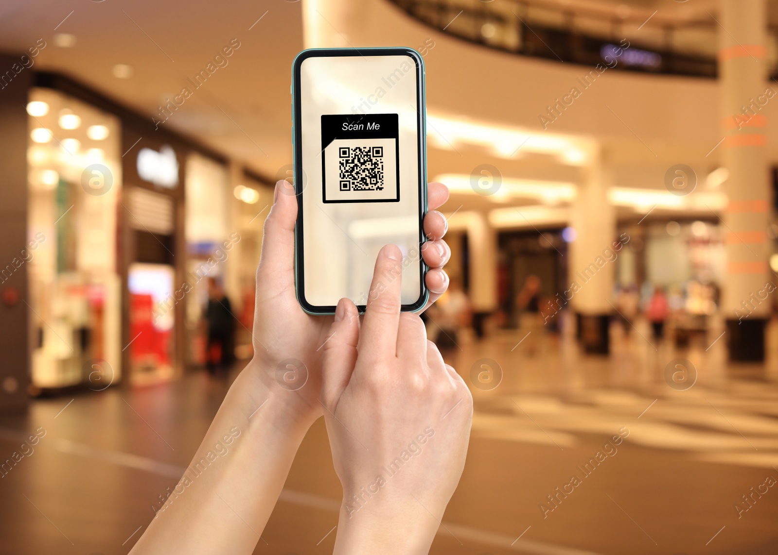 Image of Woman holding smartphone with QR code on screen in shopping mall, closeup