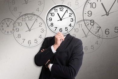 Image of Time management concept. Businessman with clock instead of head on light grey background