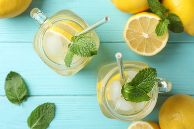 Photo of Natural lemonade with mint on light blue wooden table, flat lay. Summer refreshing drink