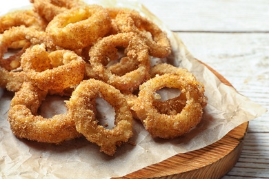 Photo of Homemade crunchy fried onion rings on table, closeup