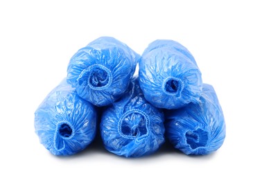 Photo of Many rolled blue shoe covers isolated on white