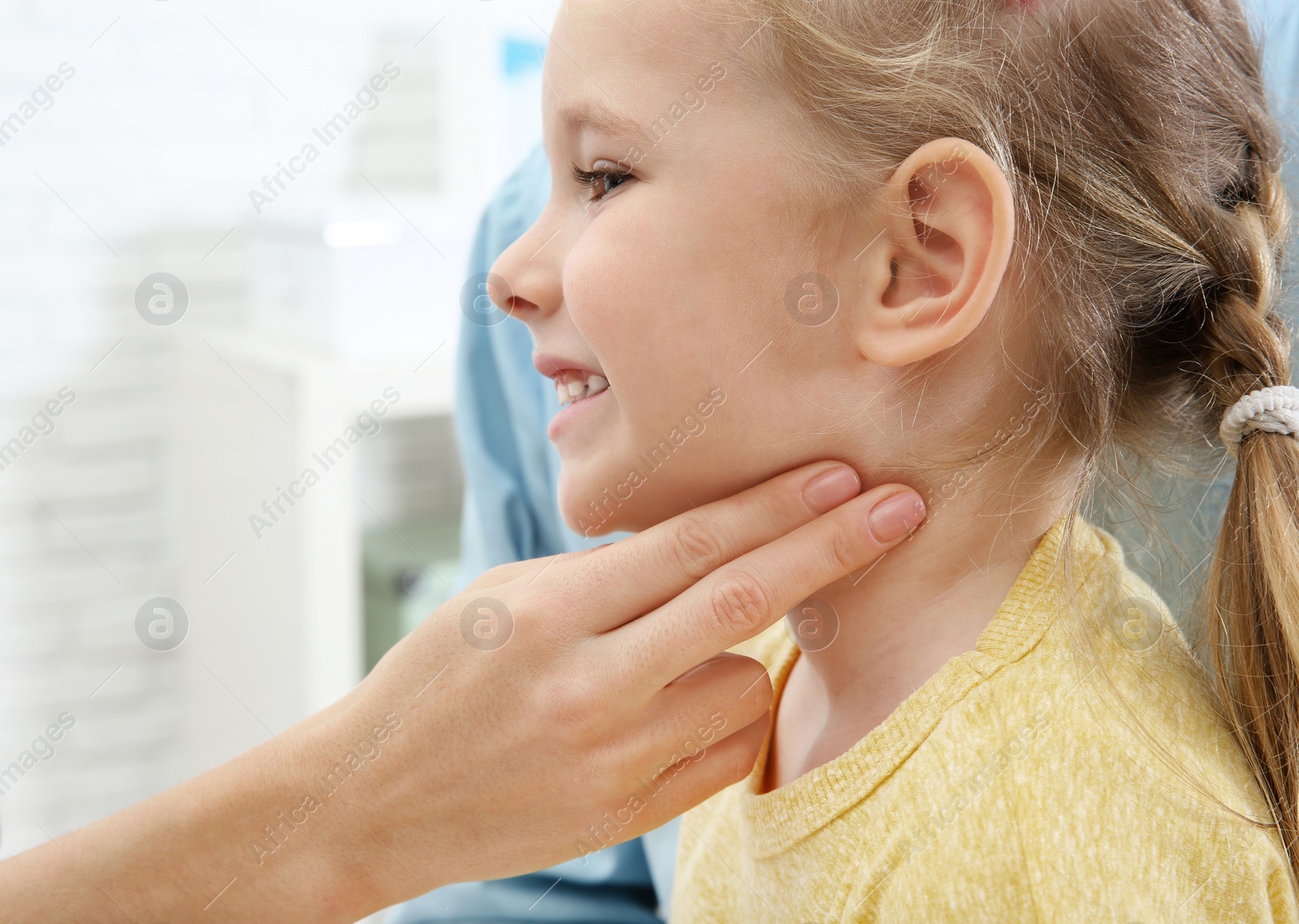 Photo of Young woman checking little girl's pulse with fingers indoors