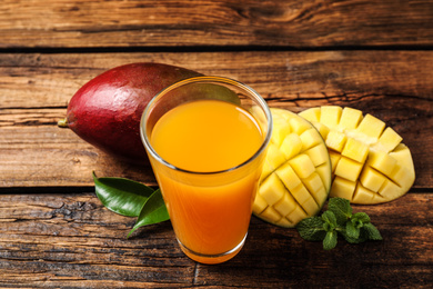 Photo of Fresh delicious mango drink on wooden table