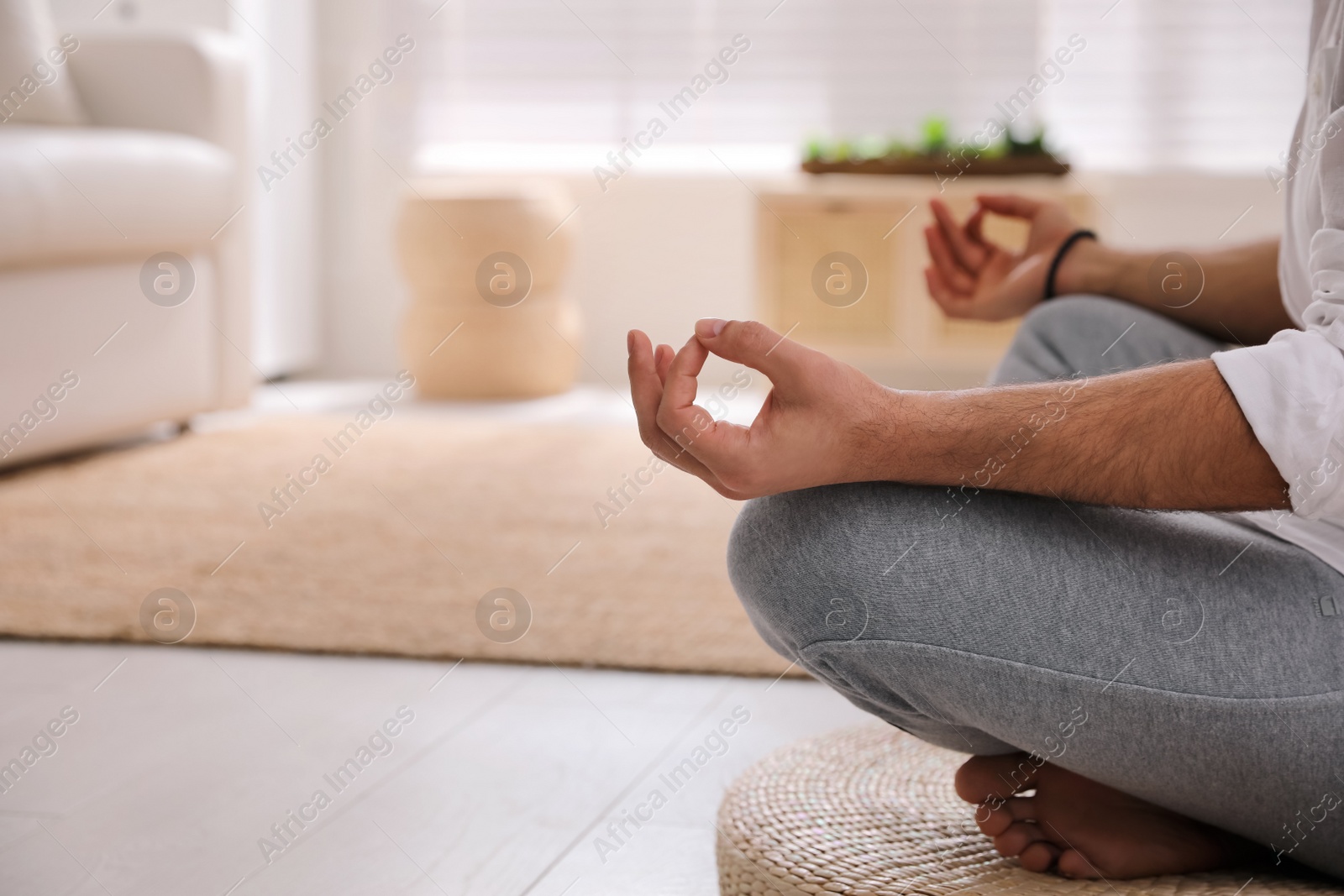 Photo of Man meditating on wicker mat at home, closeup. Space for text