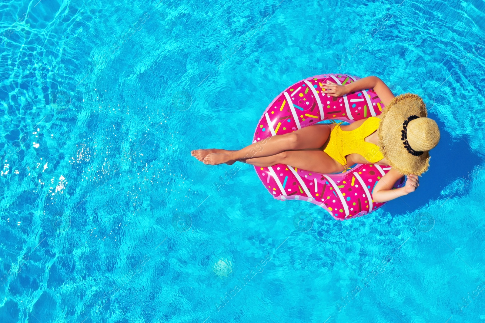 Image of Young woman with inflatable ring in swimming pool, top view. Space for text