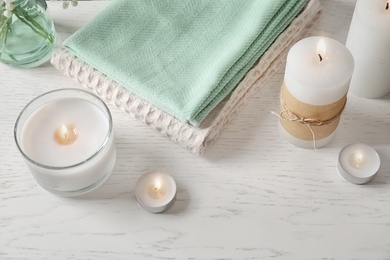 Photo of Beautiful composition with burning wax candles on light background