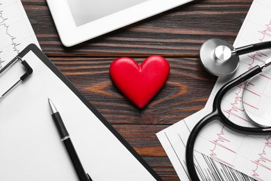 Photo of Flat lay composition with stethoscope and red heart on wooden table. Cardiology concept