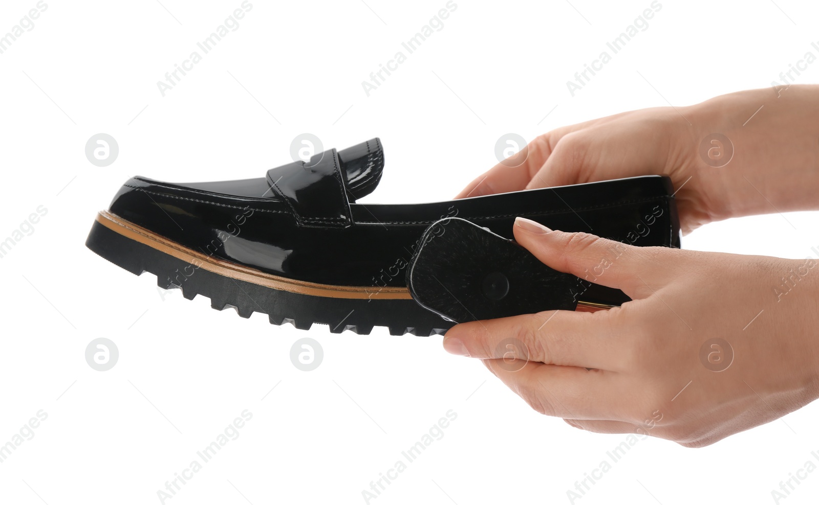 Photo of Woman cleaning stylish footwear on white background, closeup. Shoe care accessories