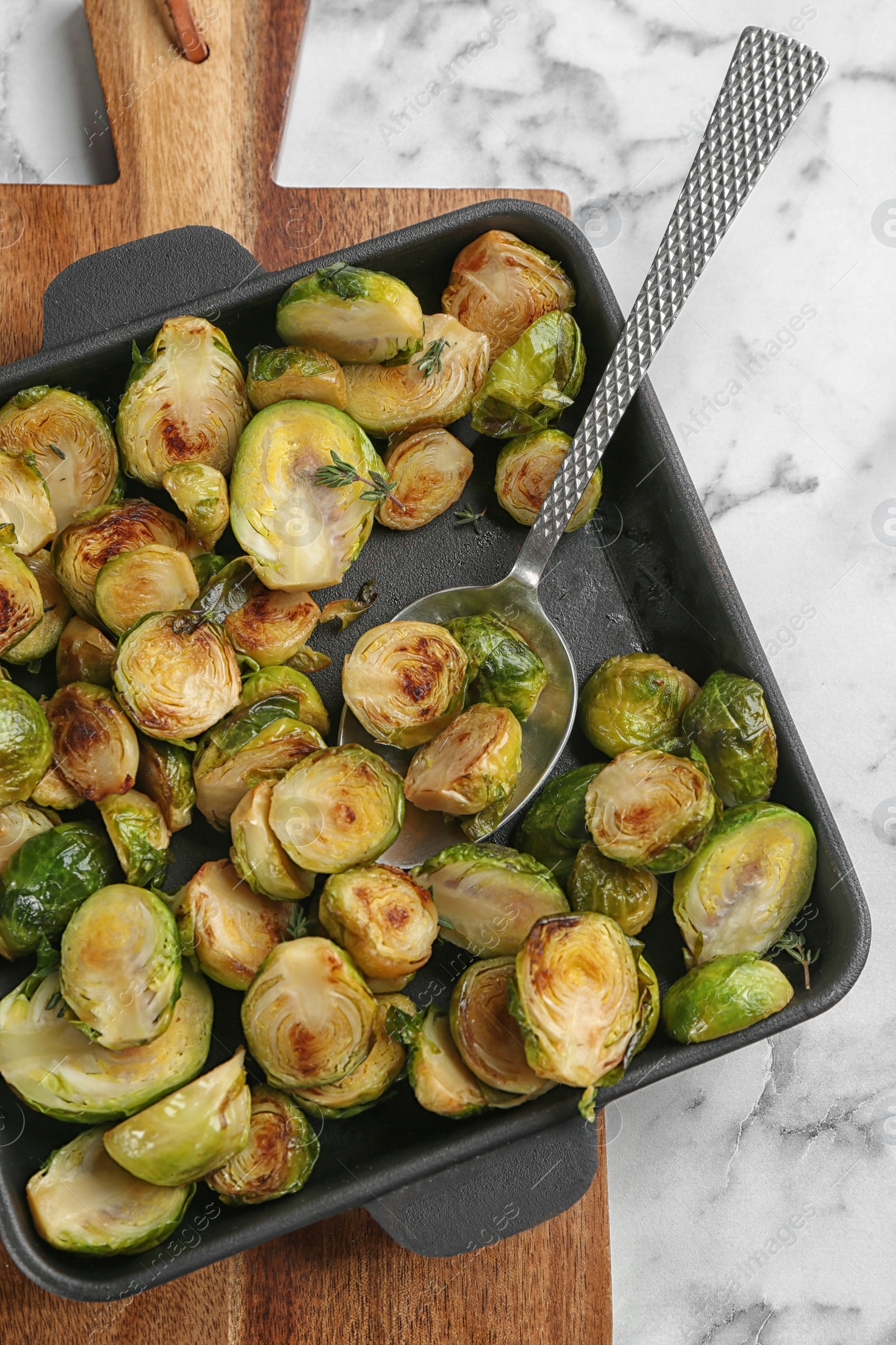 Photo of Delicious roasted brussels sprouts on white marble table, top view