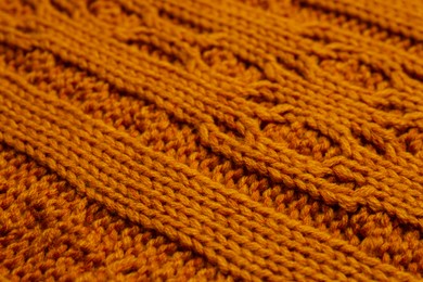 Photo of Beautiful orange knitted fabric as background, closeup