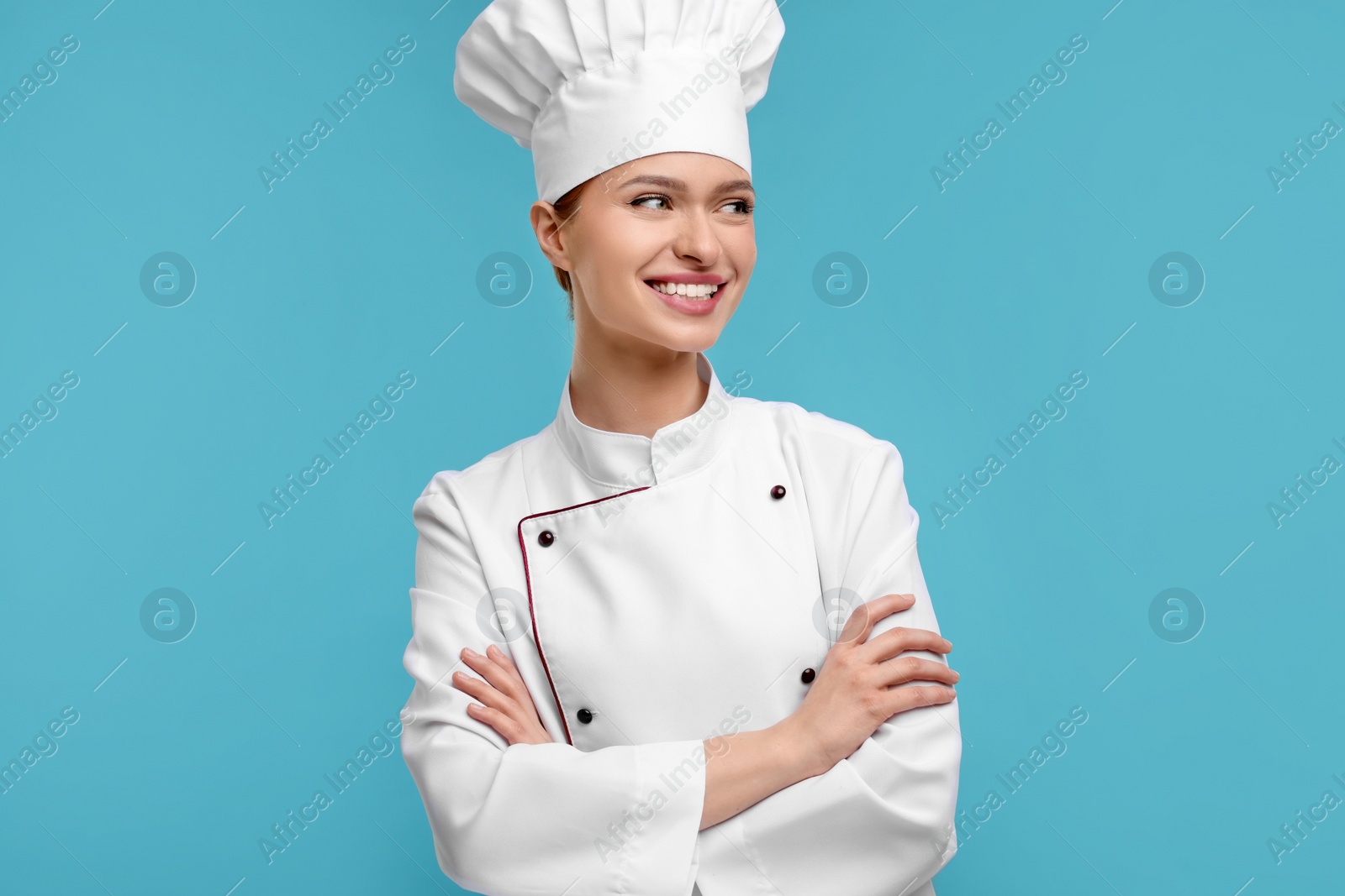 Photo of Happy chef in uniform on light blue background