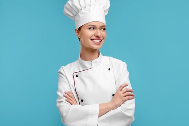 Happy chef in uniform on light blue background