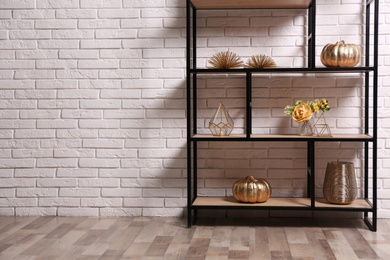 Photo of Shelving with different decor near white brick wall, space for text. Interior design