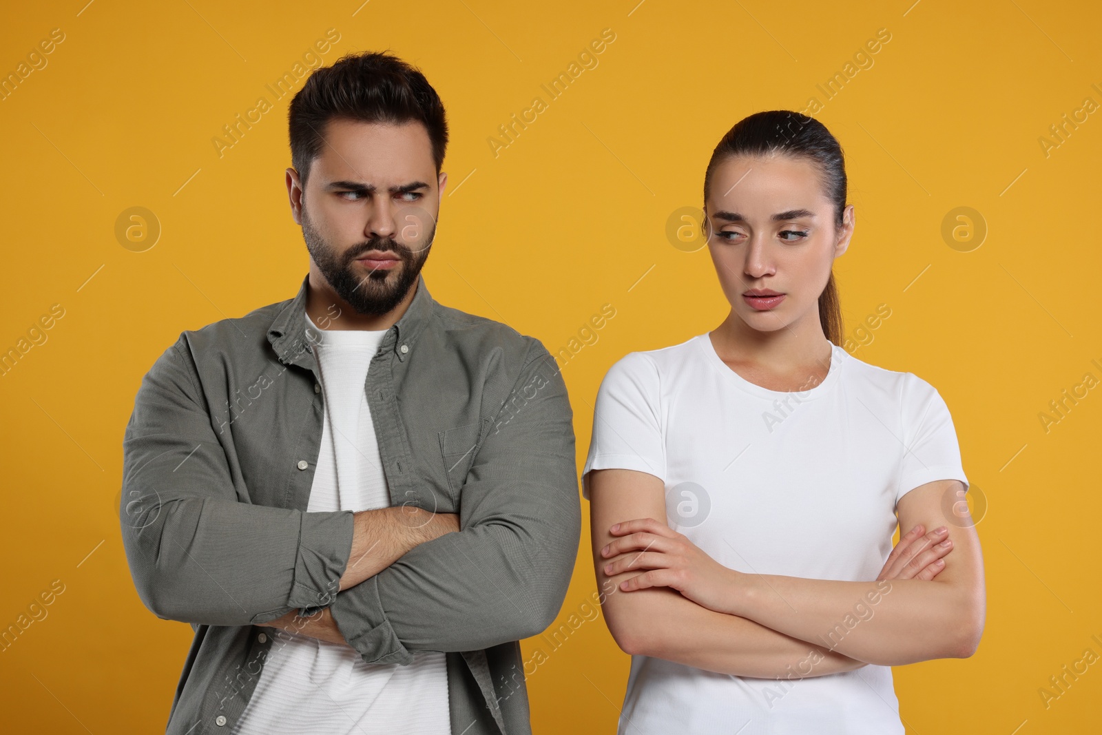 Photo of Resentful couple with crossed arms on orange background