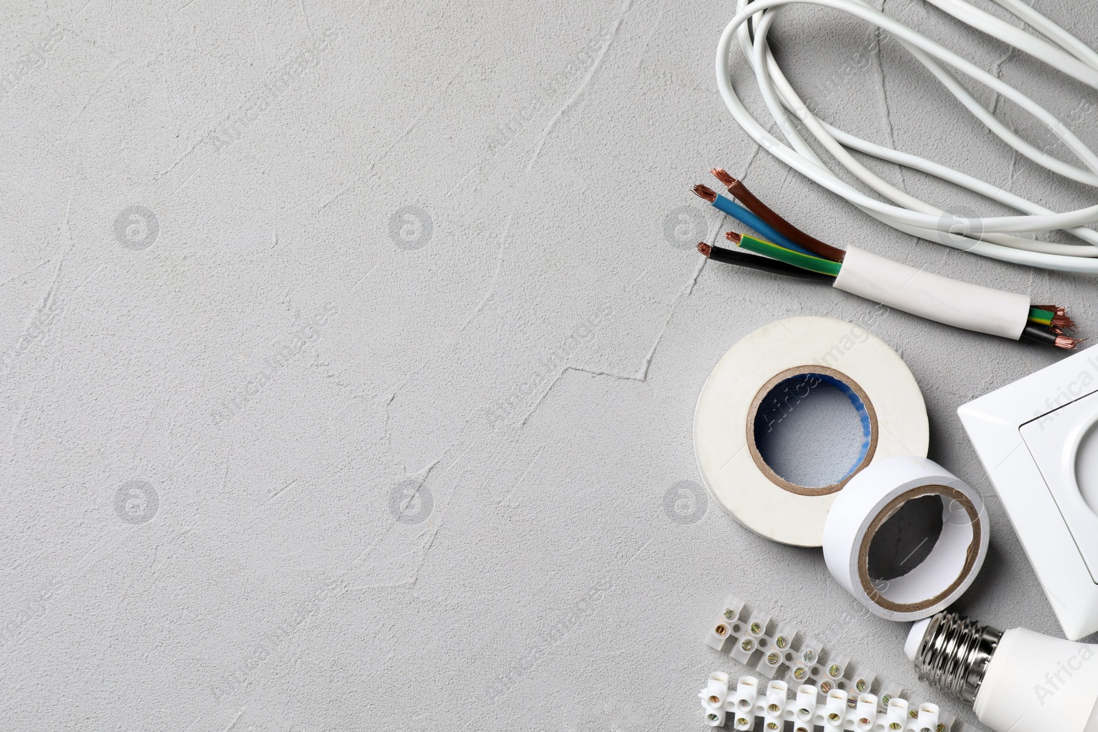 Photo of Set of electrician's accessories on grey background, flat lay. Space for text