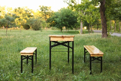 Photo of Wooden picnic table with benches in park