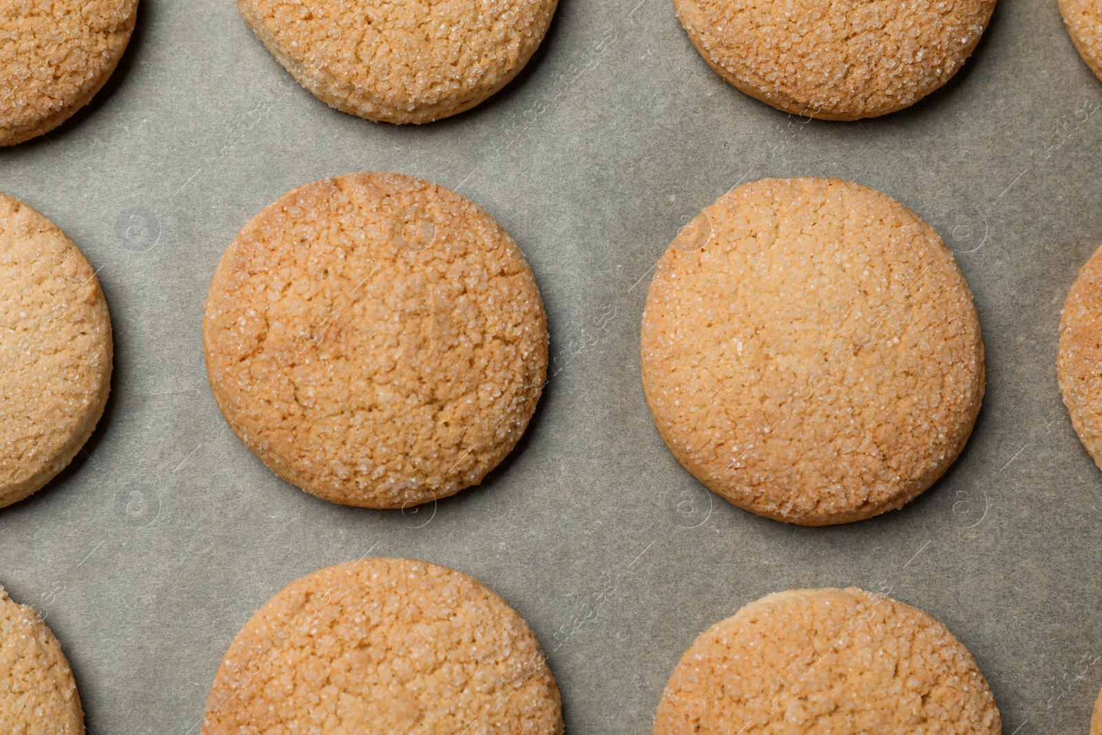 Photo of Delicious sugar cookies on parchment paper, flat lay