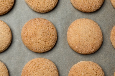 Photo of Delicious sugar cookies on parchment paper, flat lay