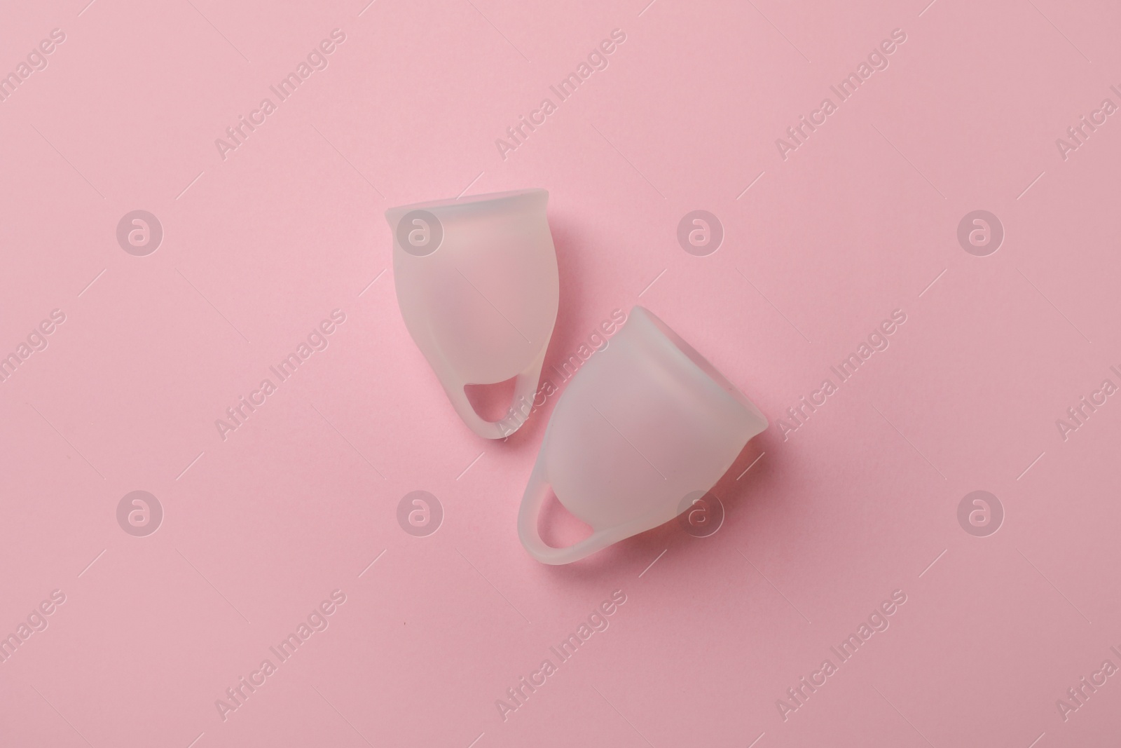 Photo of White menstrual cups on pink background, flat lay